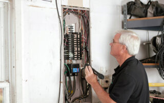 person examining oldelectrical panel inside home